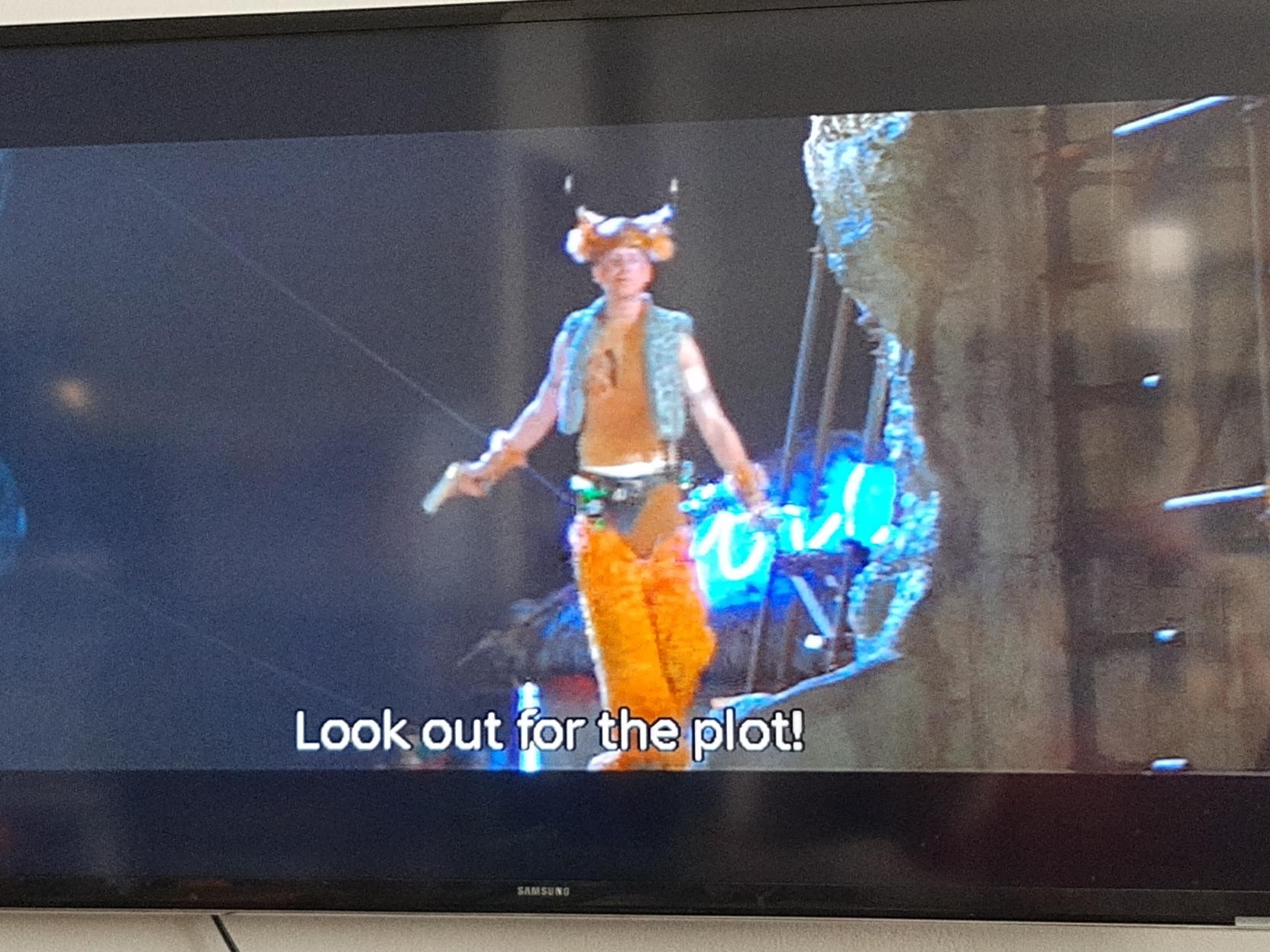 Photo of my TV showing a shirtless young man in shag orange chaps and a horned helmet from a scene in Romeo and Juliet. He is shouting, and it is captioned "Look out for the plot!"